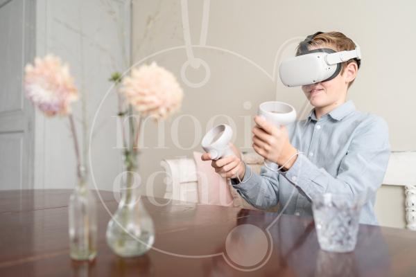 Jongen speelt met VR-bril aan tafel 1