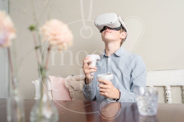 Jongen speelt met VR-bril aan tafel 2