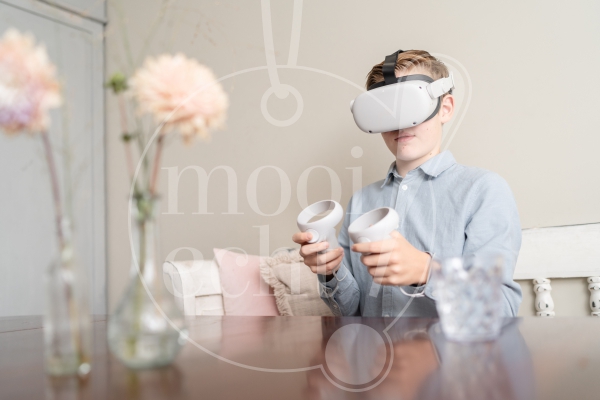 Jongen speelt met VR-bril aan tafel 3