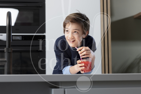 Jongen met smoothie in de keuken
