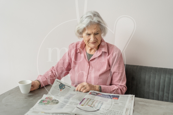 Vrouw leest de krant en drinkt koffie 3