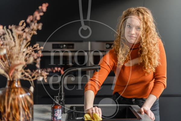 Vrouw maakt het aanrecht schoon 1