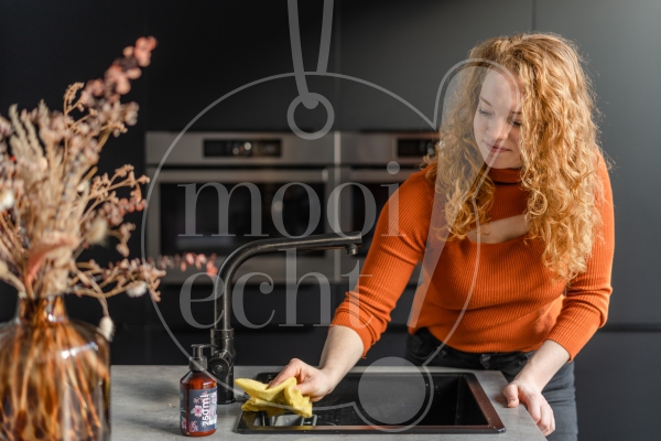 Vrouw maakt het aanrecht schoon 2