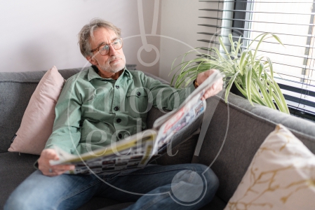 Man leest krant op de bank 1