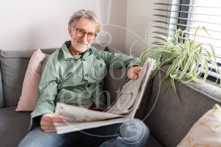 Man leest krant op de bank 2