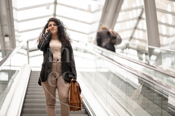 Vrouw aan het bellen op de roltrap 2