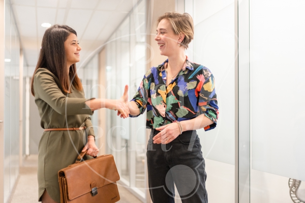 Twee vrouwen geven elkaar een hand